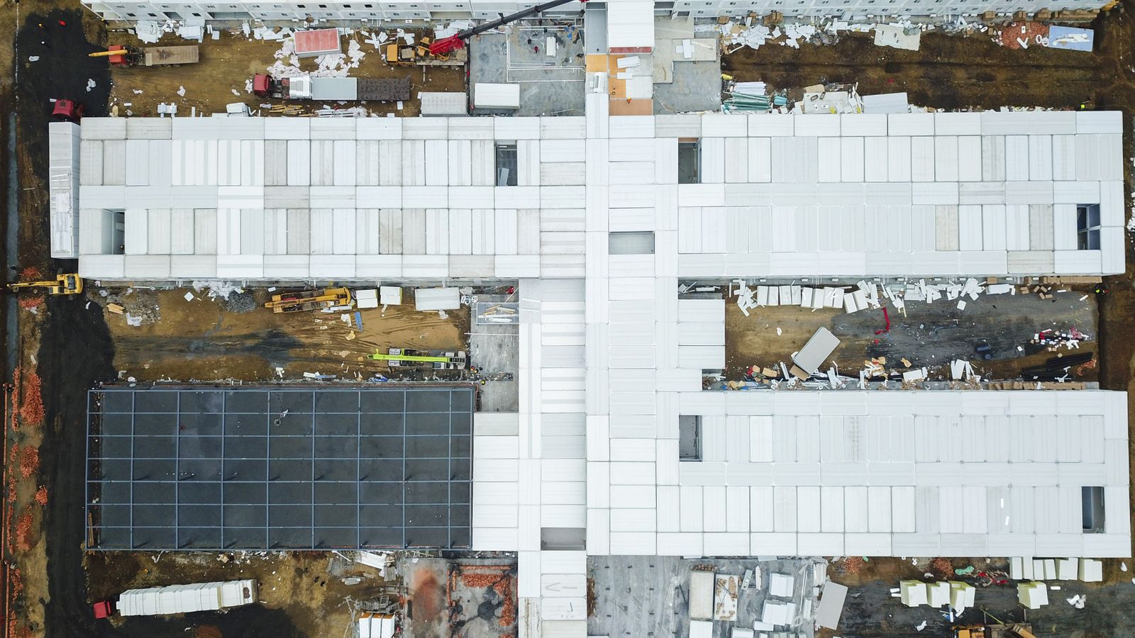 Drone shot capturing aerial view of a large construction site with unfinished buildings.